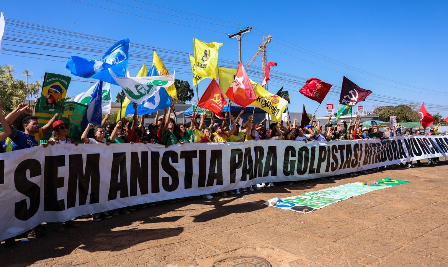 Manifestantes queimam bandeira dos EUA e boneco de Trump em embaixada