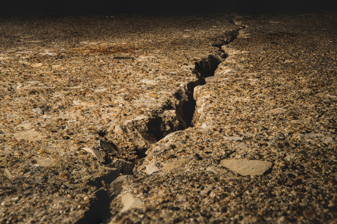  A split ground covered in stones under the sunlight with a blurry background