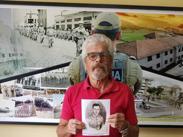 Edilson Orlei Ferreira de Souza em 2025 segurando a foto do pai