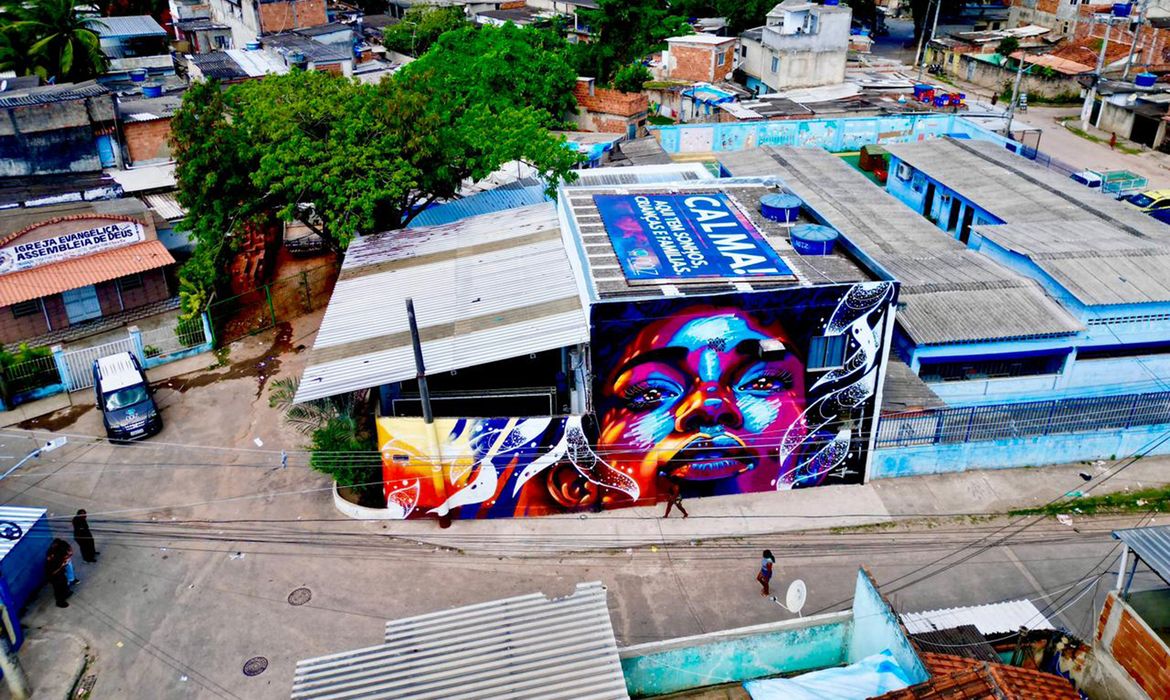 Telhado na Cidade de Deus diz: "Aqui tem crianças, sonhos e famílias"